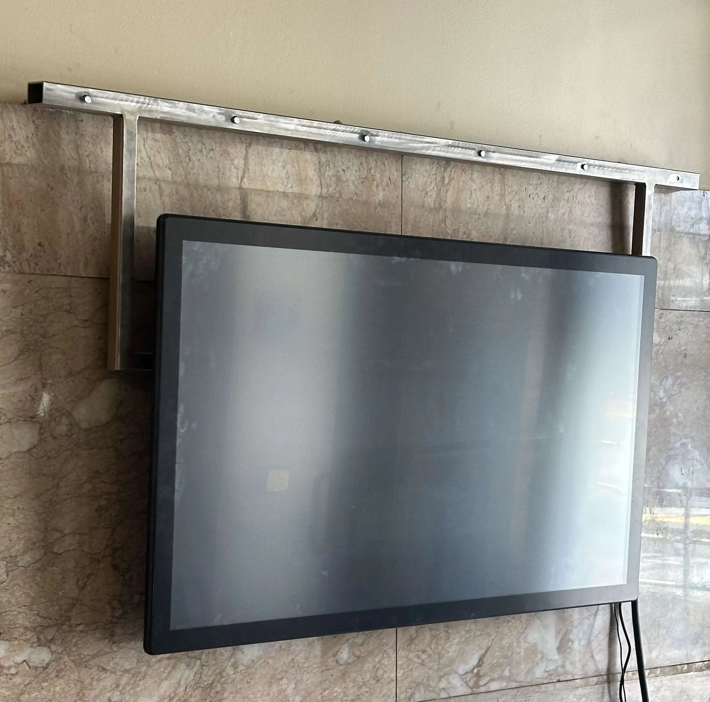 Sleek black multi-touch display mounted on a marble wall, ready for interactive museum exhibits.