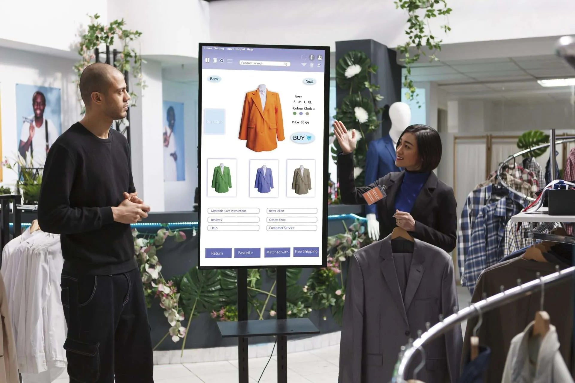 Two people interacting with a large, vertical interactive kiosk displaying clothing options in a modern retail store.